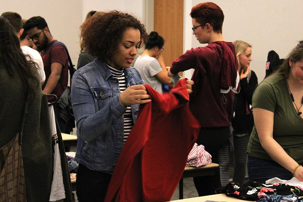 Sunshine Spiva, a second-year pursuing a double major in Spanish and psychology, holds up a sweater that she found at the Spring Clothing Swap in Talley Student Union on Friday, March 22. The clothing swap was open to all students who donated items in return for being able to pick out an item of their choice.