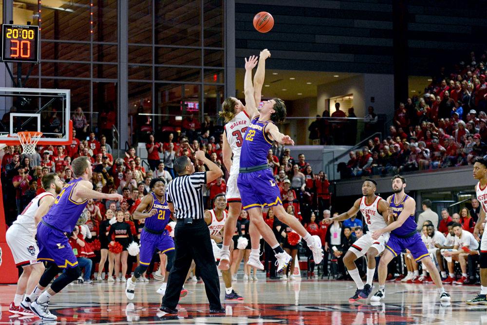 Graduate forward Wyatt Walker reaches during the tip-off in Reynolds Coliseum on Wednesday, March 27, 2019. Walker racked up 10 rebounds and 3 points. The Wolfpack lost 94-93 to Lipscomb, causing them to get knocked out of the NIT and end their season.