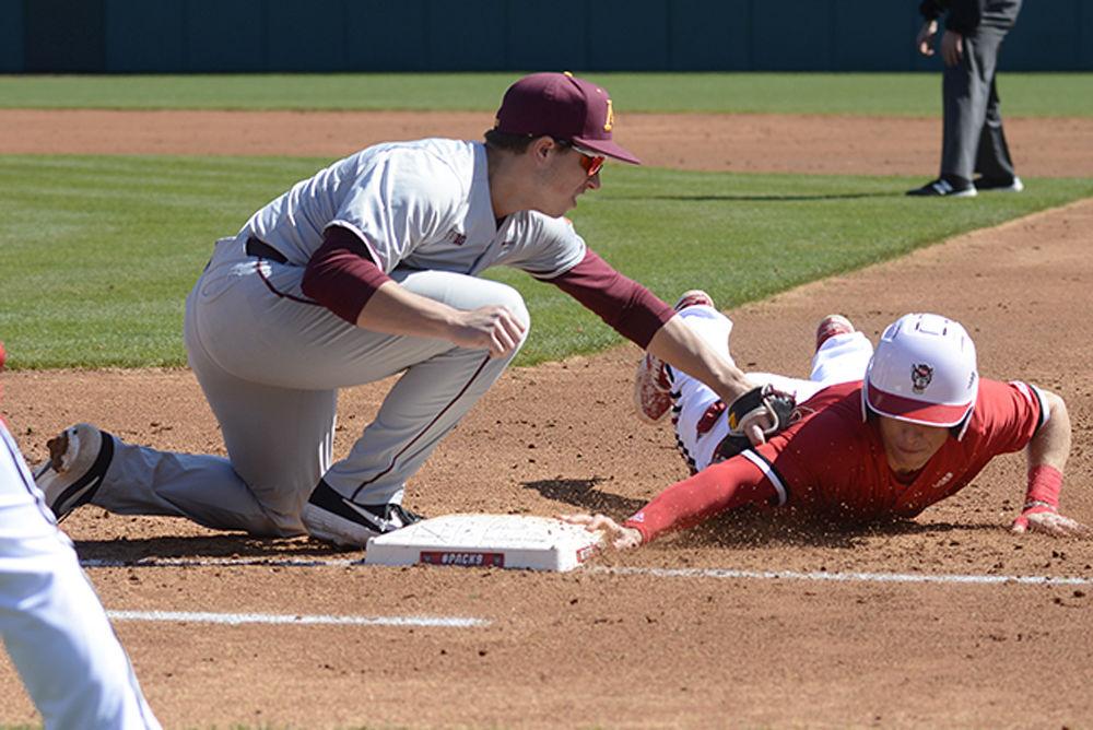Freshman infielder Vojtech Mensik dives back to first base to avoid a pickoff on Saturday March 2, 2019 at Doak Field. The Wolfpack beat the Gophers 3-2 during the first game of the doubleheader with Mensik going 1-2.