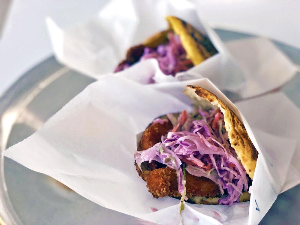 Two crispy chicken arepas, made fresh to order and topped with coleslaw with Isla sauce on the side.