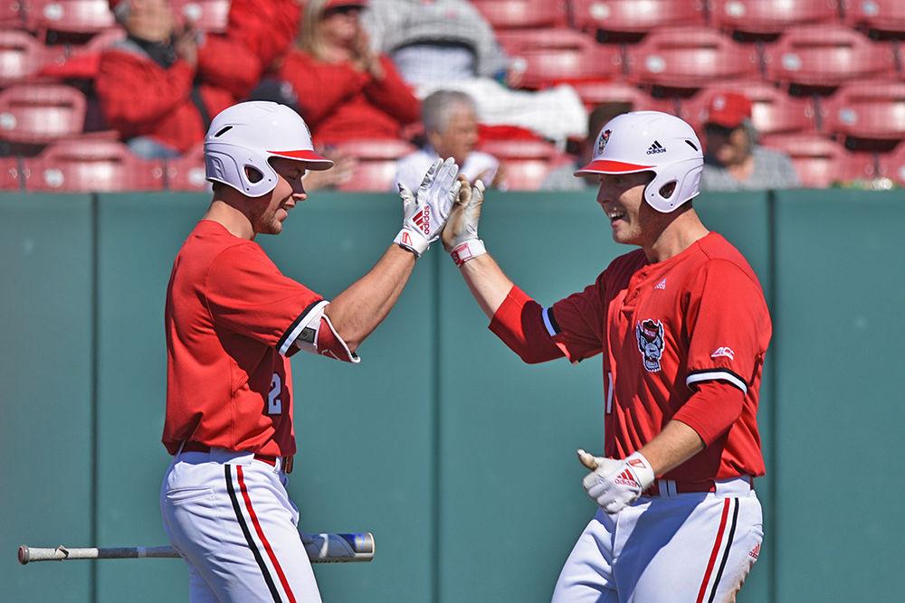 Sophomore outfielder Jonny Butler and junior catcher Brad Debo high-five during the game against Minnesota on Saturday, March 2, 2019 at Doak Field. The Wolfpack won 3-2.
