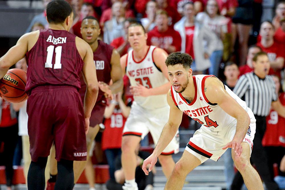 Sophomore guard Devon Daniels defends Harvard guard Bryce Aiken during NC State's second round NIT game on Sunday, March 24, 2019 in Reynolds Coliseum. Daniels scored 14 points during the Wolfpack's 78-77 victory over the Crimson.