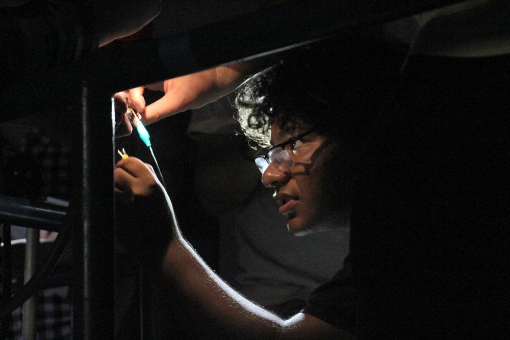 Christian Alvarado, a high school student, corrects wire connections to obtain proper readings and analyze results for a group project at a nuclear engineering summer camp in July 2015. The camp is held annually for high school students interested in nuclear engineering.