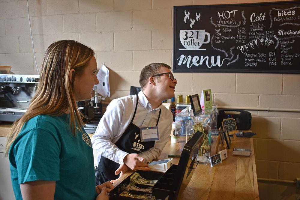 Matthew Schwab and volunteer Steph Wasik, a sophomore in first-year engineering, greet customers from the newly added 321 Coffee stand located at the State Farmers Market on Saturday, April 20, 2019.