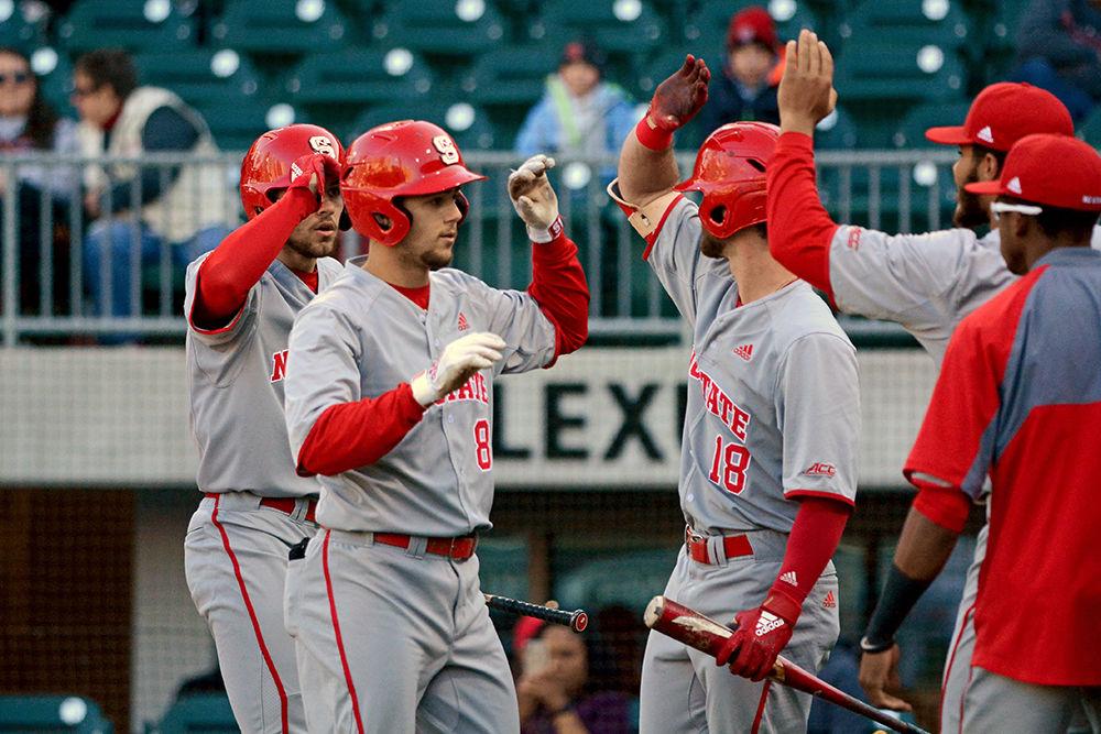 Junior shortstop Will Wilson high fives senior first baseman Evan Edwards after hitting a home run against South Carolina on April 2 at the BB&amp;T Ballpark in Charlotte. Wilson had one run for the Pack, who lost 10-8 to the Gamecocks.