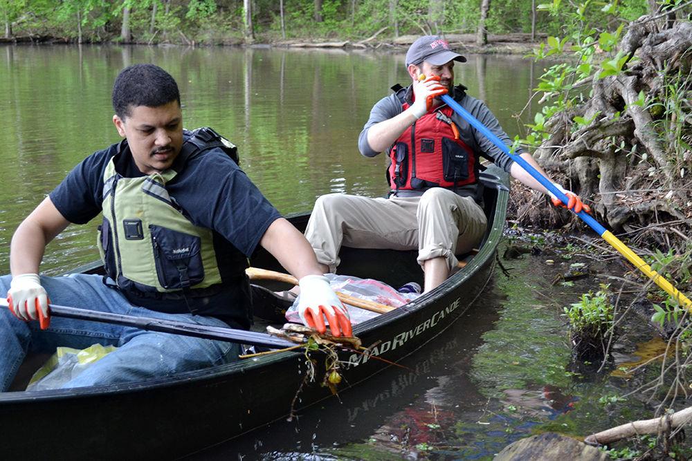 Evan Ransom, an employee at the Alamo Drafthouse Cinema, and Nathan Williams, assistant director of NC State Outdoor Adventure, clean up trash along the shores of Lake Raleigh on Sunday, April 21 for Earth Day Clean Up and Service Day.&#160;Volunteers worked in teams to pick up trash, maintain trails and remove invasive plants.