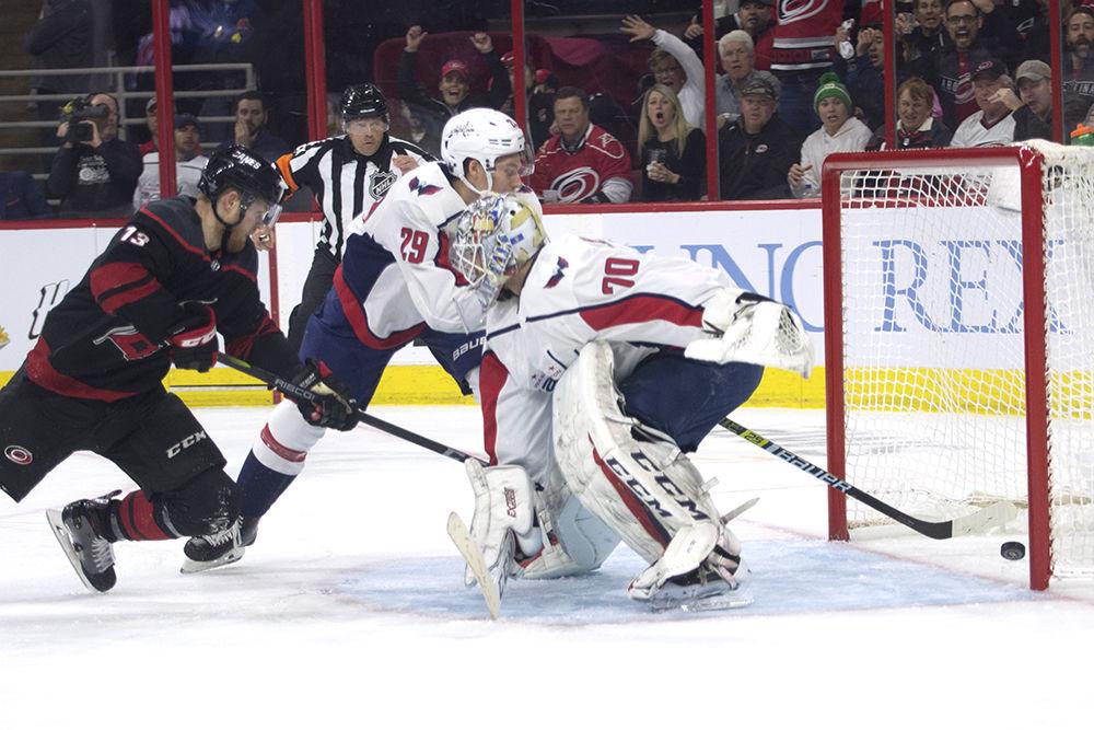 Left wing Warren Foegele falls into Washington Capitals goalie Braden Holtby, providing enough momentum to nudge the puck into the goal in PNC Arena, Monday, April 15. Foegele and teammate Dougie Hamilton were both one goal away from a hat trick, helping the Canes shut out defending Stanley Cup Champions, 5-0 in regulation.