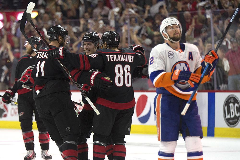 Left winger Teuvo Teravainen celebrates a goal on an empty net with Brock McGinn and Jordan Staal as New York Islanders defenseman Nick Leddy reviews the play, Wednesday, May 1. The Canes beat the New York Islanders with home ice advantage, 5-2, and lead the series with a 3-0 advantage.