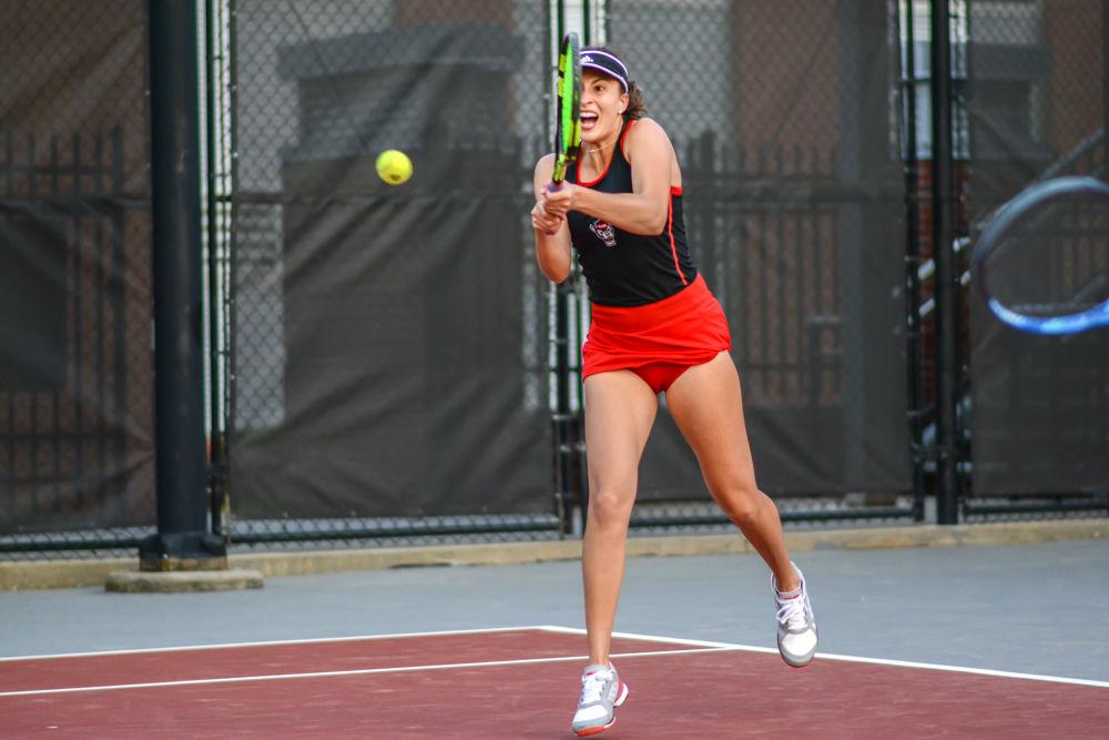 Senior Bianca Moldovan hits a backhand during her doubles match against Winthrop on Sunday, April 7 at J.W. Isenhour Tennis Center. Moldovan lost her doubles match 6-3, but won her singles match 6-2, 4-6, 6-1. The Wolfpack won overall with a score of 4-3.