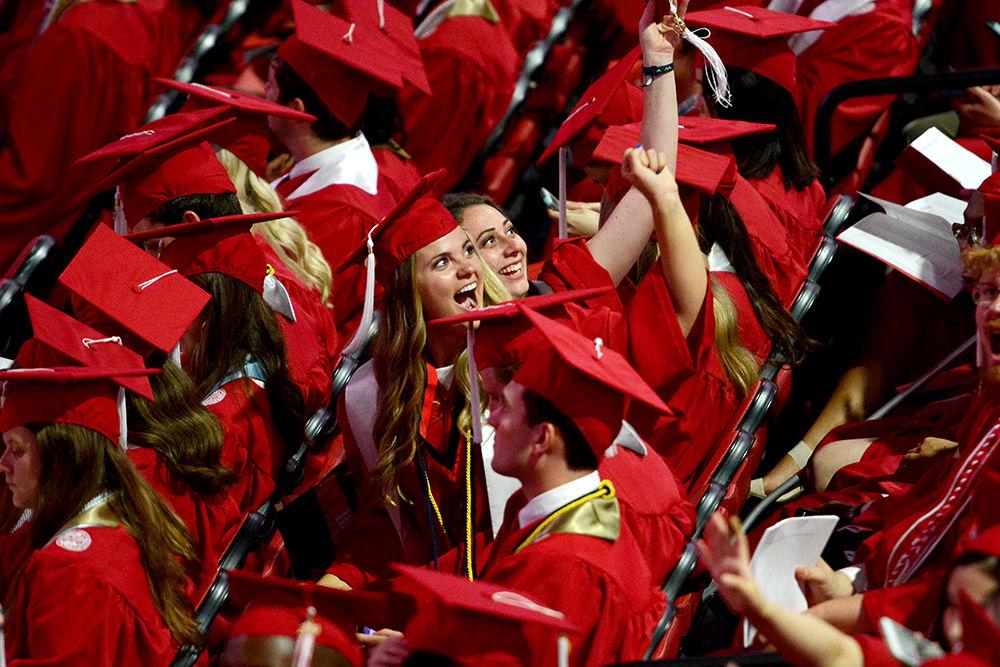 Recent Class of 2019 graduates smile and show their NC State pride during the Commencement Ceremony on Saturday, May 11, 2019 in PNC Arena.