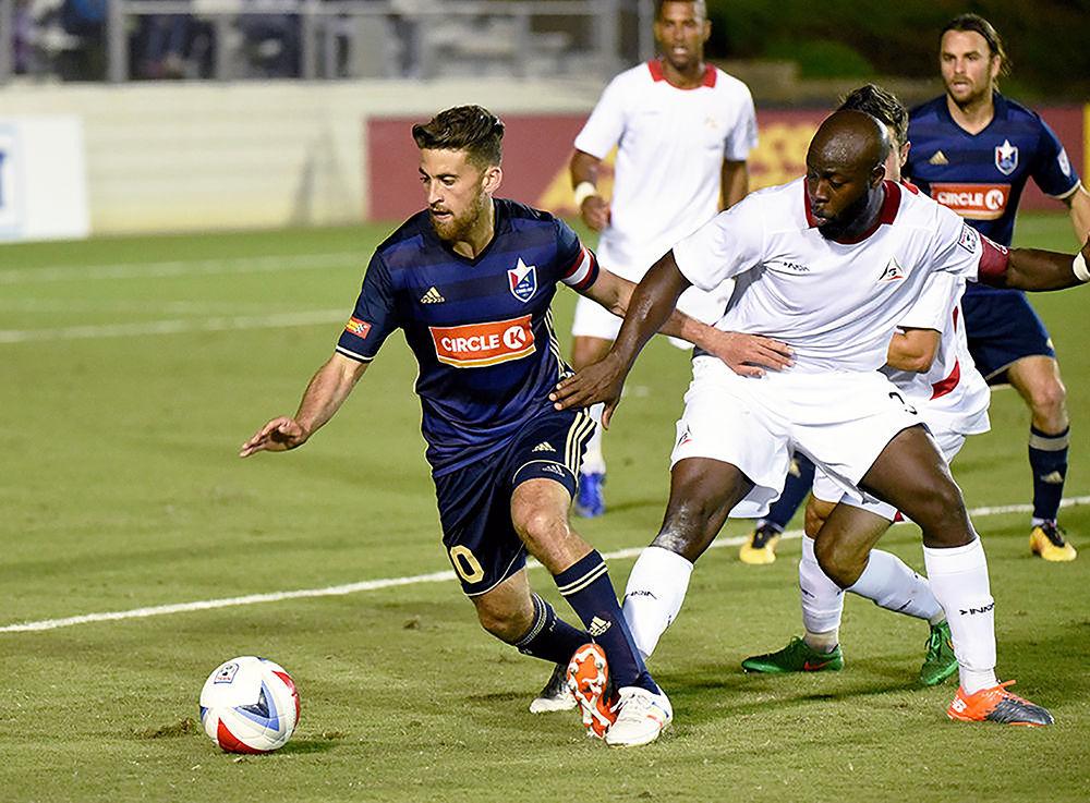 Nazmi Albadawi, a former NC State Soccer player and current midfielder for North Carolina FC, evades an opponent during a game in June 2017.