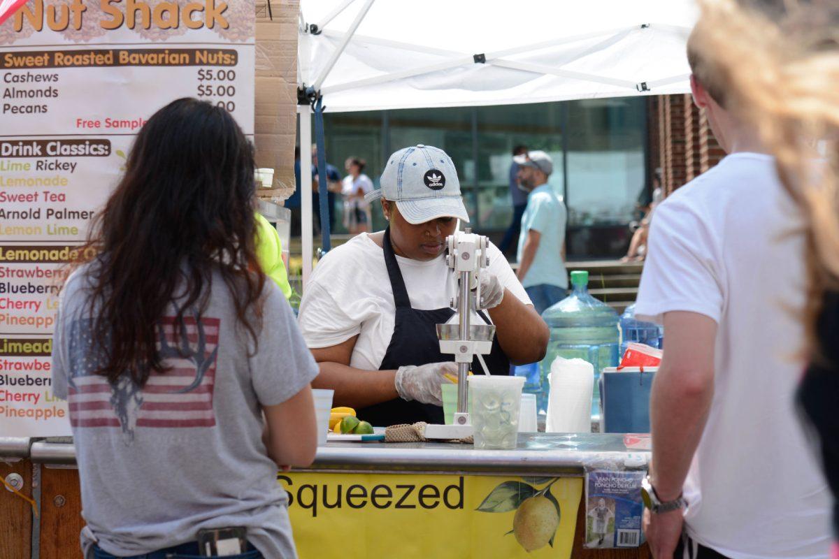 Kool Fun Nut Shack employee Shakira Smith squeezes a lemon for customers at the international festival on Saturday, Jun. 8, 2019 at City Plaza in downtown Raleigh.