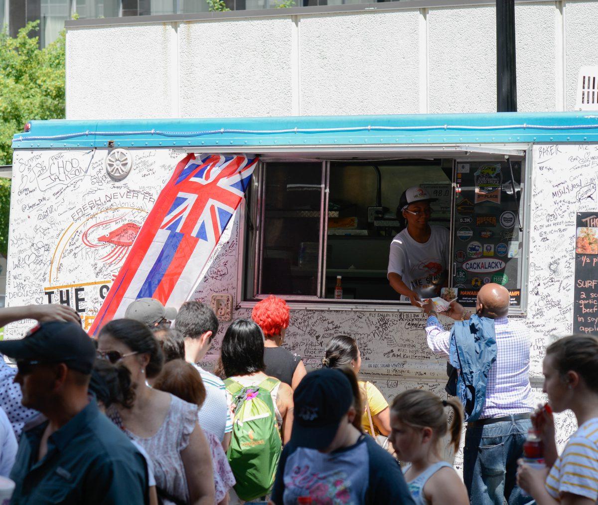 A man is served food from The Shrimp Truck at the international food festival on Saturday, Jun. 8, 2019 at City Plaza in downtown Raleigh.