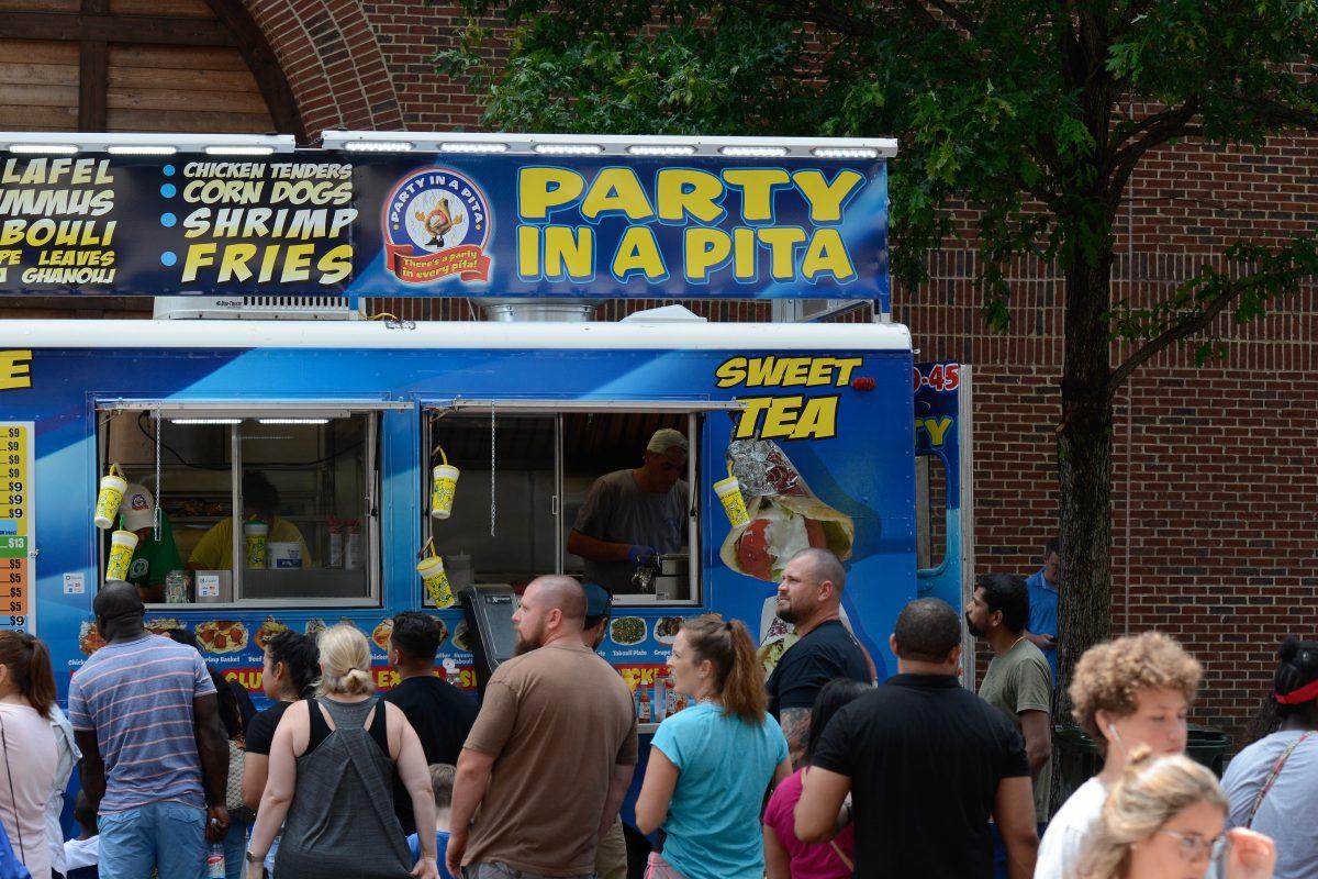 Customers wait in line to purchase food at the Party In a Pita truck, at the international food festival on Saturday, Jun. 8, 2019 at City Plaza in downtown Raleigh.