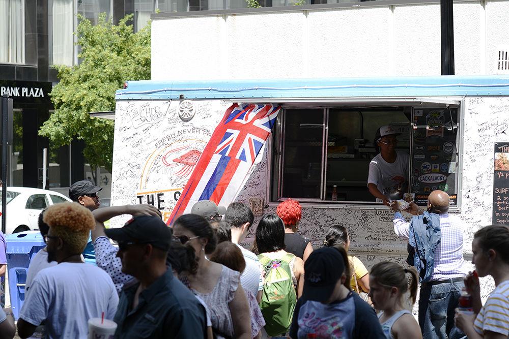 An employee from The Shrimp Truck serves food to a customer at the international food festival on Saturday, Jun. 8, 2019 at City Plaza in downtown Raleigh.