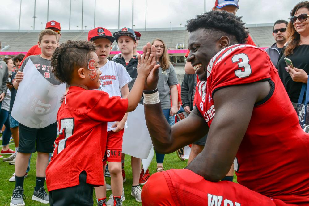 Junior wide receiver Emeka Emezie high-fives a young fan after the Kay Yow Spring Game on Saturday, April 6, 2019 at Carter-Finley Stadium. Emezie will be a major contributor to the Wolfpack&#8217;s passing game this fall.