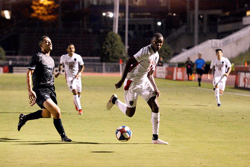 Sophomore Kuda Muskwe dribbles the ball towards the goal during the game against Loyola on Friday, August 30, 2019. Muskwe had one goal and two shots against the Greyhounds. The Wolfpack beat Loyola 2-1.