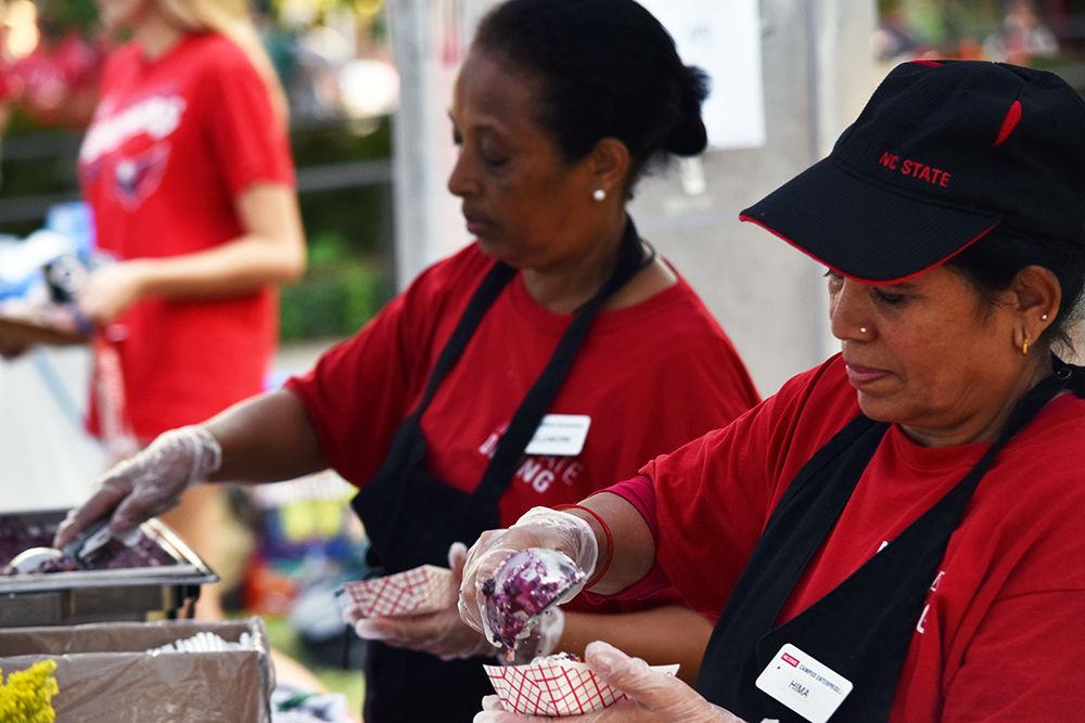 Hima Sedai and Muluwork Mekuirya serve cobbler to NCSU students attending All Carolinas Meal at Fountain Dining Hall on Tuesday, Sept. 10, 2019. All Carolinas Meal is an annual event hosted by NCSU dining that features Carolina themed food and music.