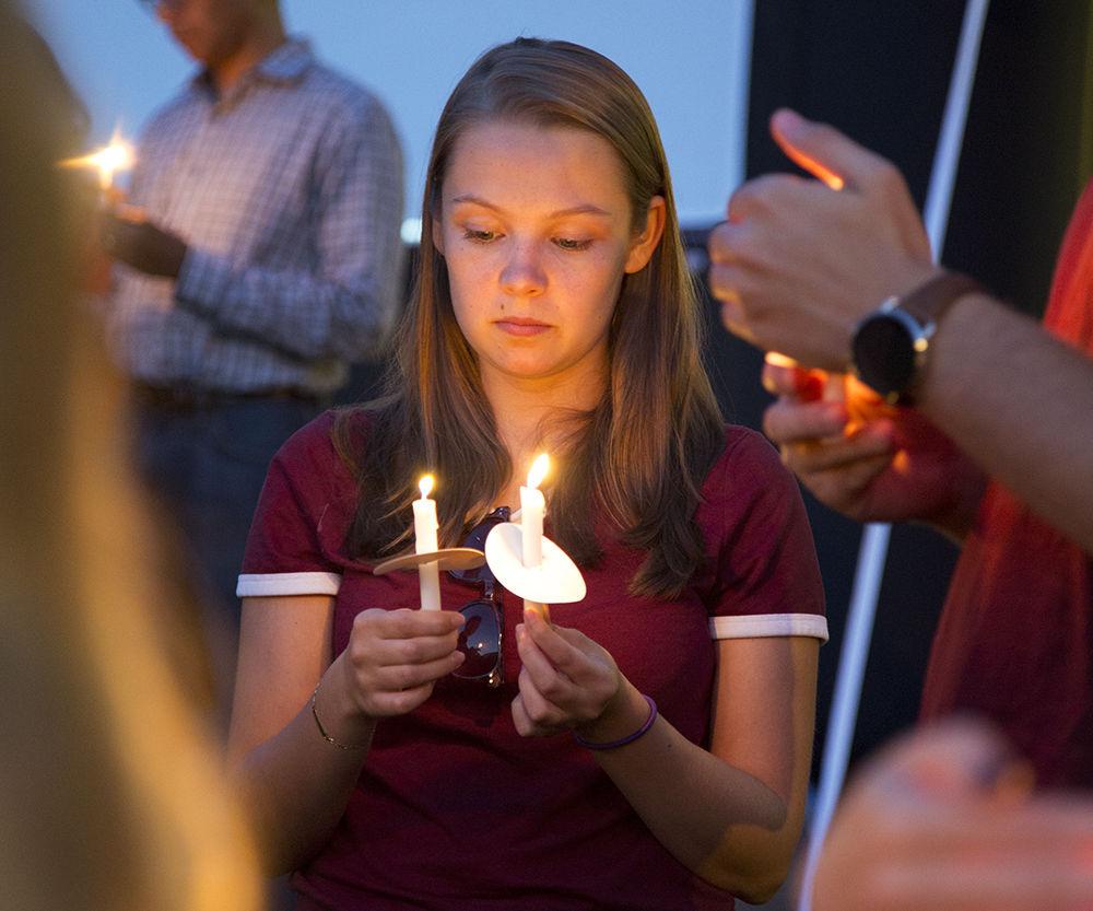 Gabrielle Heffernan, a sophomore studying Nutrition, holds a candle at the Suicide Prevention Vigil on Tuesday, Sept. 10, 2019. A moment of silence was held on Harris Field to bring awareness to the ever growing suicide epidemic across the globe.