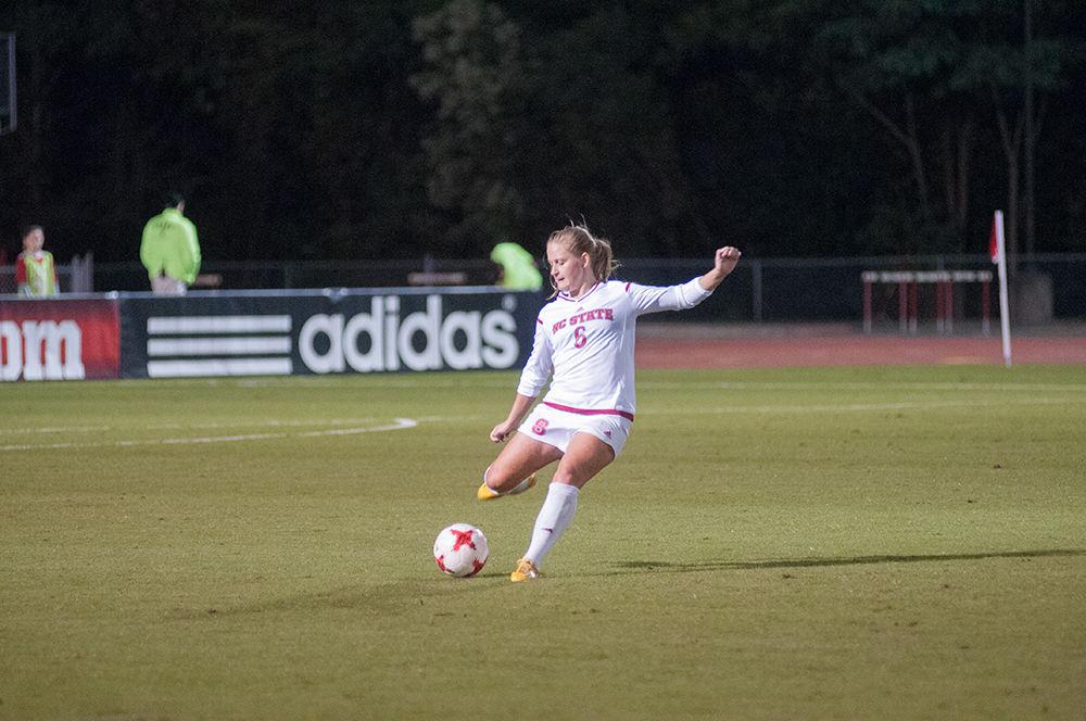 Freshman defender Lulu Guttenberger kicks the ball to a teammate at the N.C. State V. Louisville women's soccer game in Dail Soccer Stadium on Thursday, Oct. 26. The wolfpack won against the cardinals with a final score of 2-1.