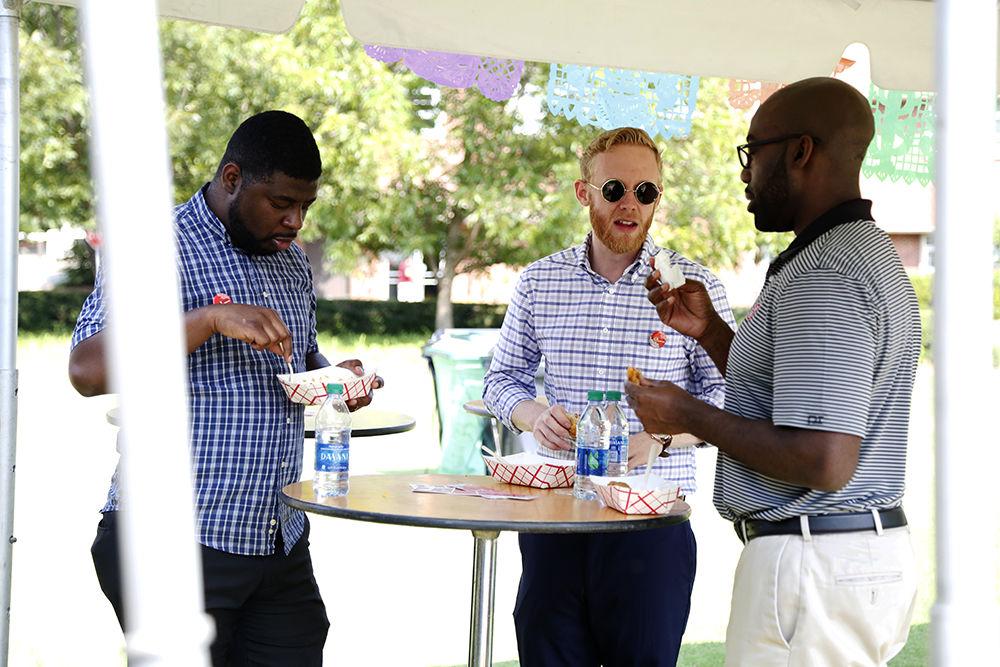 Student advisers, Keith Martin and Ayo Agunbiade, and graduate assistant academic adviser, Tommy Yandle enjoy the free food offered at the Latinx Barrio Party held at General Scoot Courtyard on Tuesday, Oct. 1, 2019. "It's a beautiful exposure for the whole community to honor Latin excellence and explore a new culture" says Agunbiade. "Cuban food is amazing, especially being from Miami, this is close to home" says Martin. Free food was offered to both staff and students to celebrate Hispanic Heritage month.
