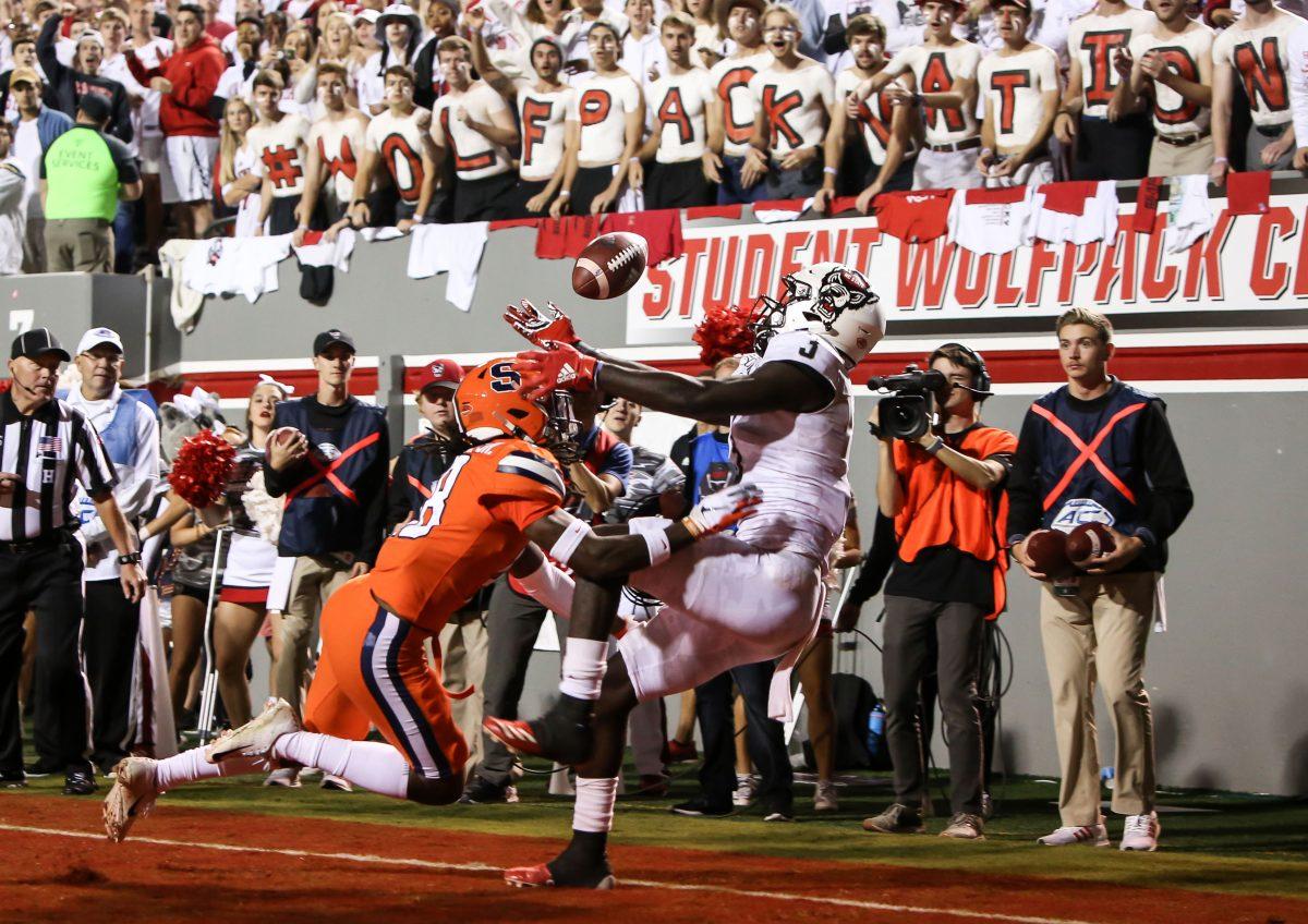 NC State junior receiver Emeka Emezie (3) struggles to collect a pass in the end zone after having it deflected by Syracuse defender Scoop Bradshaw (18). NC State hosted Syracuse Orange on Thursday, October 10, 2019. NC State won the game 16-10. Emezie led the team in receiving with 77 yards on 5 catches.