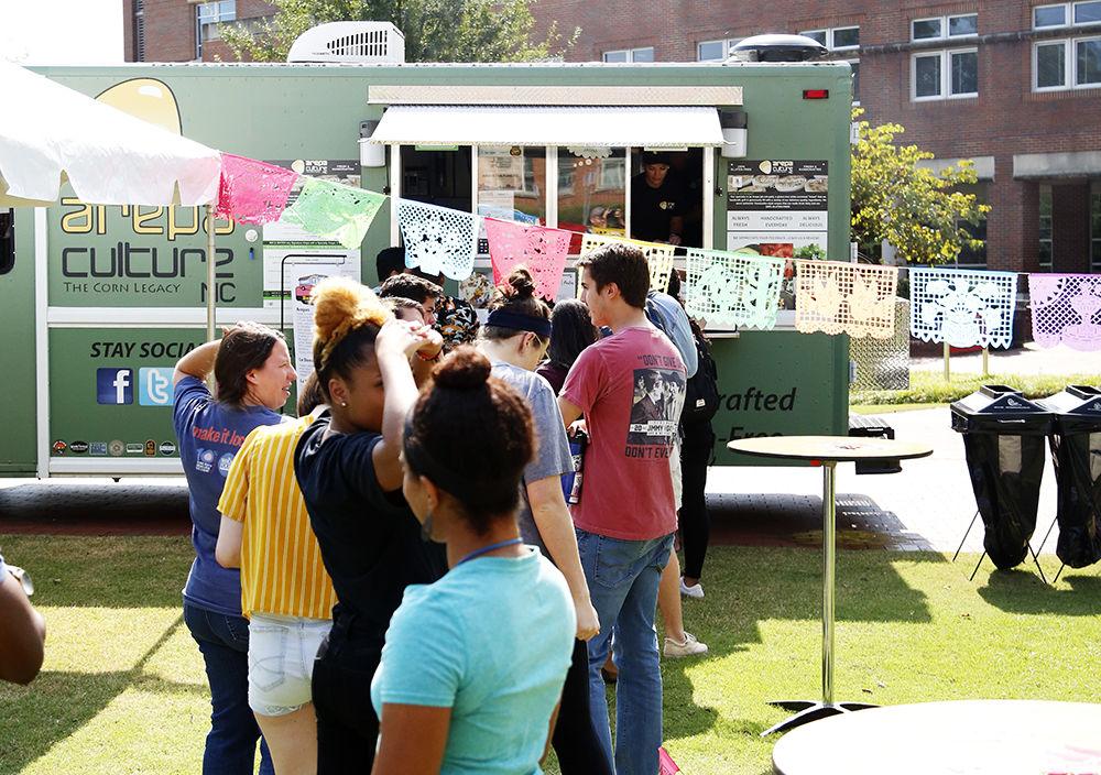 Faculty and Students line up for the "Spanglish" food truck serving Puerto Rican and Cuban cuisine samples at the Latinx Barrio Party held at General Scott Courtyard on Tuesday, Oct. 1, 2019. This event was organized by the Diversity and Inclusion team based in Poole College Office of Undergraduate Programs.