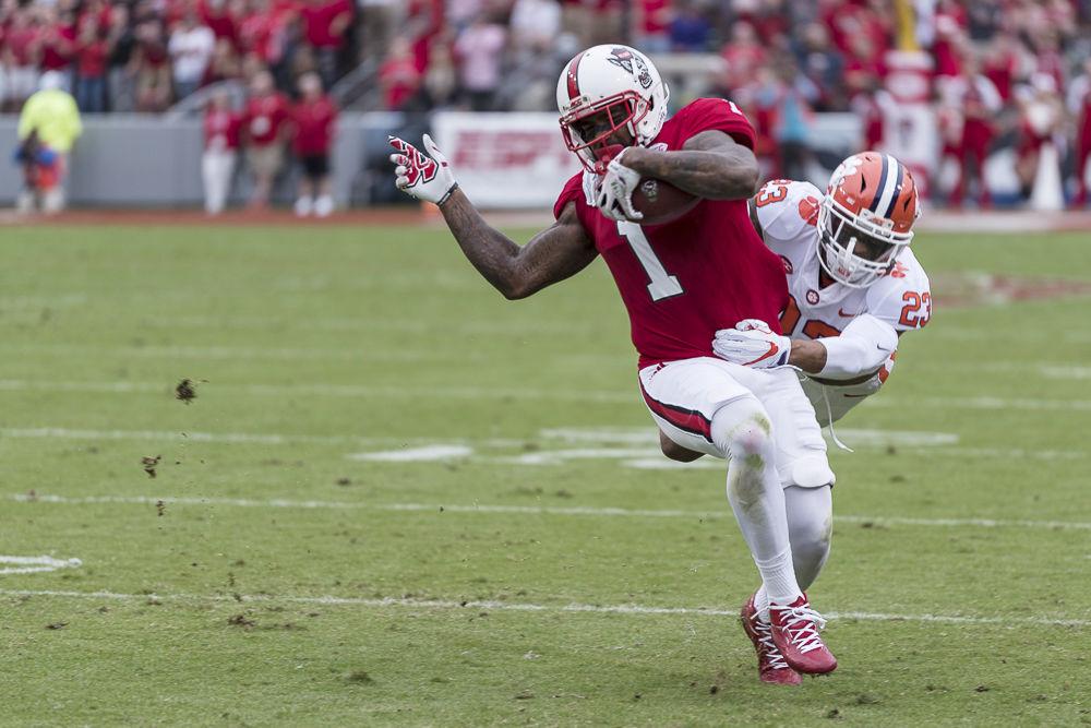 Senor Halfback Jaylen Samules runs a cut while dragging Clemson safety Van Smith. The Wolfpack lost 31-38 against the Tigers on Saturday November4 at Carter-Finley Stadium.
