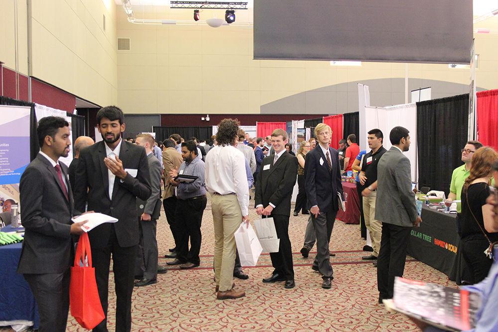 Students walk to and from different booths at the NCSU Engineering Career Fair hosted at the McKimmon Center on Sep.20. NCSU and non-NCSU students, some of which had traveled far distances, were able to search for co-op, internship, and full-time positions at participating companies. The event took place over two days where different companies such as IBM and GE had booths.
