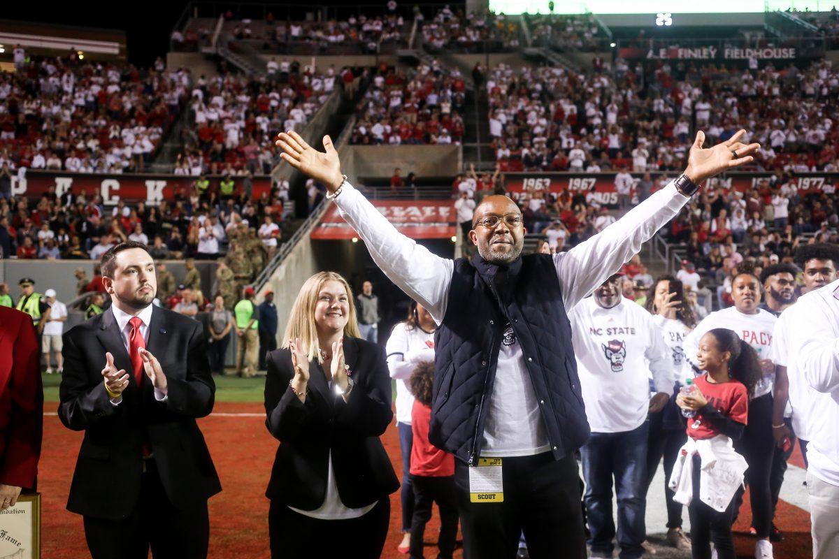 Former NC State wide receiver Torry Holt celebrates his induction into the College Hall of Fame during a stoppage in play of the Wolfpack's 16-10 home win against the Syracuse Orange on Thursday, October 10, 2019. Holt will be inducted on Dec. 10, 2019, after a distinguished career at NC State where he still holds numerous ACC records, and an 11-year career in the NFL with multiple All Pro seasons and a Super Bowl championship. His senior season of 1998, he totaled 1,604 receiving yards, and his average of 145.8 yards per game is over 20 yards better than any other receiver in ACC history.