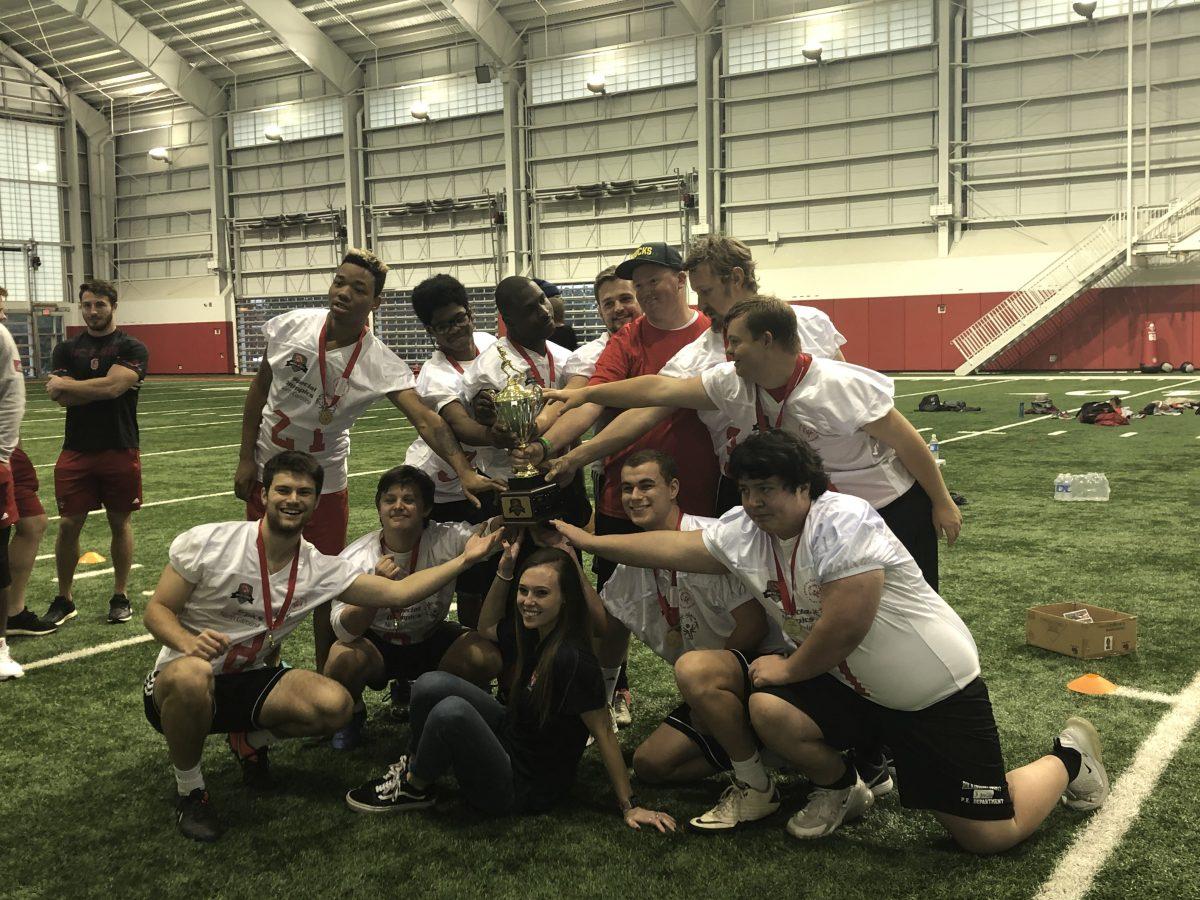 The NC State Special Olympic Unified team poses with the trophy after beating UNC-Chapel Hill 30-22 at Close-King Indoor Practice Facility on Saturday, Nov. 23, 2019.&#160;