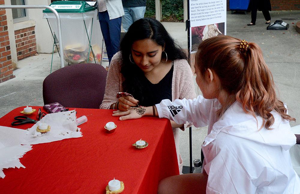 Eiman Azam, a second year majoring in business administration and statistics, draws henna on Harley Crumpler at the Diwali festival, hosted by the Poole College of Management. Diwali is a Hindu festival of lights, and marks the beginning of the fiscal year in India.