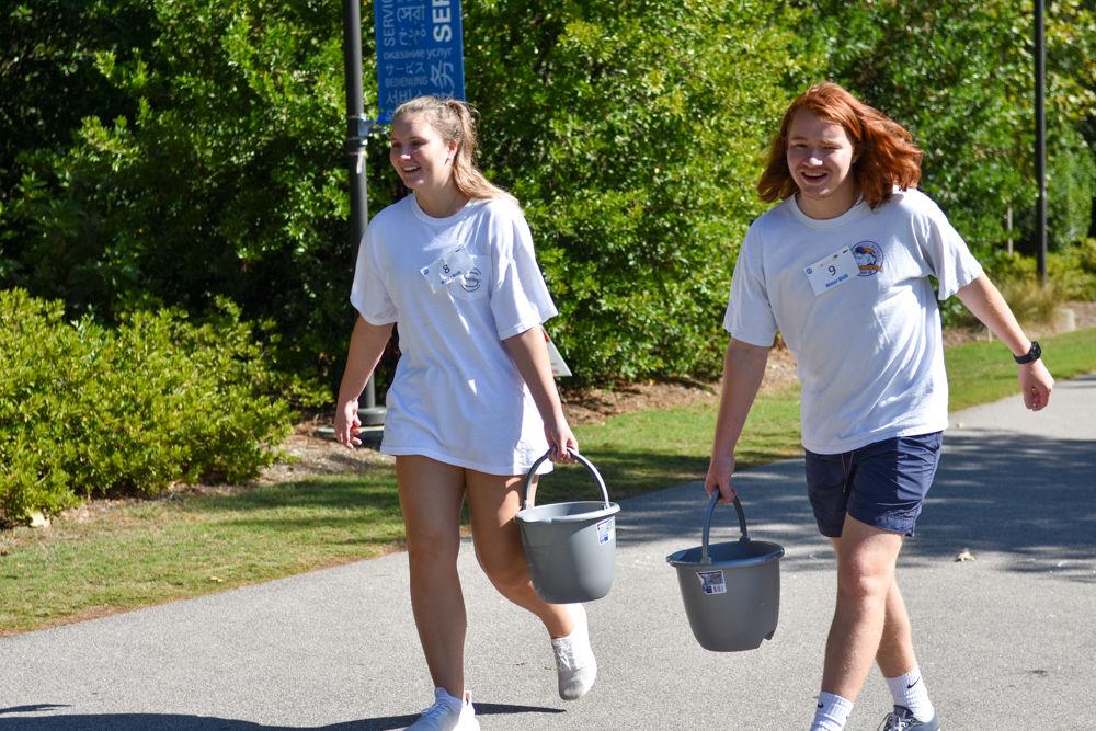 Steven And Lily carry on a conversation while walking in the Water Walk at Stafford Commons on Oct. 26, 2019. The Water Walk is an event where racers experience what it is like from a global perspective for the average women to transport clean water by walking two laps around the commons with a full bucket of water. Proceeds for this event go to support Wine to Water, an organization whose efforts go to bringing clean water to those in need.