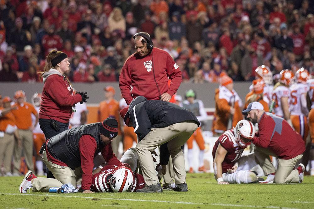 Head coach Dave Doeren watches as graduate defensive end James Smith-Williams and redshirt freshman linebacker Payton Wilson are evaluated for injuries sustained during a play against Clemson at the homecoming game in Carter-Finley Stadium, Sat. Nov. 9, 2019. The Pack lost, 10-55.