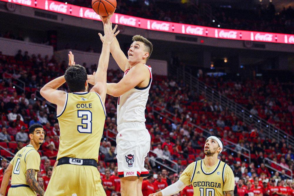 Graduate forward Danny Dixon shoots a hook shot over a Georgia Tech defender in PNC Arena on November 5, 2019. Dixon played six minutes and had four points in the Wolfpack&#8217;s 82-81 overtime loss to Georgia Tech.