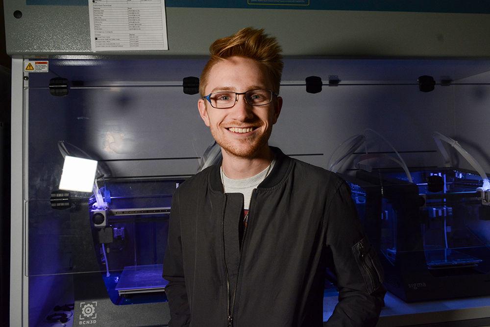 Griffin Drye, a senior in material science and the president of the Helping Hand Project, poses for a portrait in front of the Helping Hand's 3-D printers in Engineering Building III on Thursday, Nov. 21, 2019. The Helping Hand Project designs and prints prosthetic hands which are then given free of charge. They have a focus on young children, who need replacements as they grow.