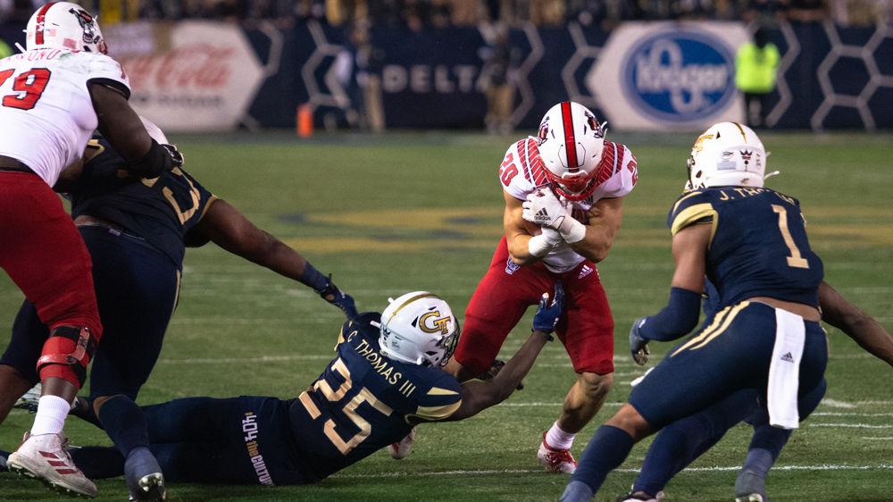 NC State freshman running back Jordan Houston protects the ball while being tackled during NC State's game against Georgia Tech at Bobby Dodd Stadium on Nov. 22, 2019. The Wolfpack lost, 28-26.