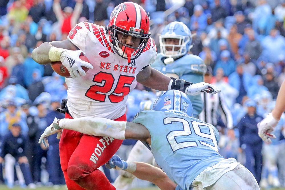 Senior running back Reggie Gallaspy Jr. dodges to the right before being tackled just short of the end zone on Saturday, Nov. 24 in Kenan Memorial Stadium. Gallaspy scored all five of the Wolfpack&#8217;s touchdowns, tying the school record for rushing touchdowns in one game. The Wolfpack won 34-28 overtime.