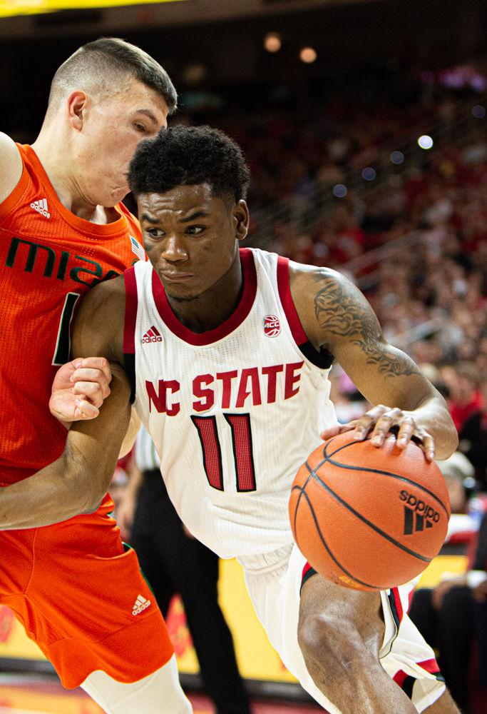 Senior guard Markell Johnson drives against Miami guard Dejan Vasiljevic on Wednesday, Jan. 15, 2020 at PNC Arena. Johnson scored 10 points as the Wolfpack won 80-63.