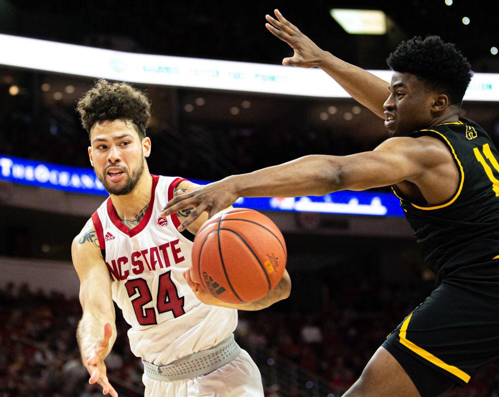 Redshirt junior guard Devon Daniels passes against Appalachian State guard/forward Donovan Gregory on Sunday, Dec. 29, 2019 at PNC Arena. Daniels recorded 18 points, 11 rebounds and four steals as the Wolfpack won 72-60.