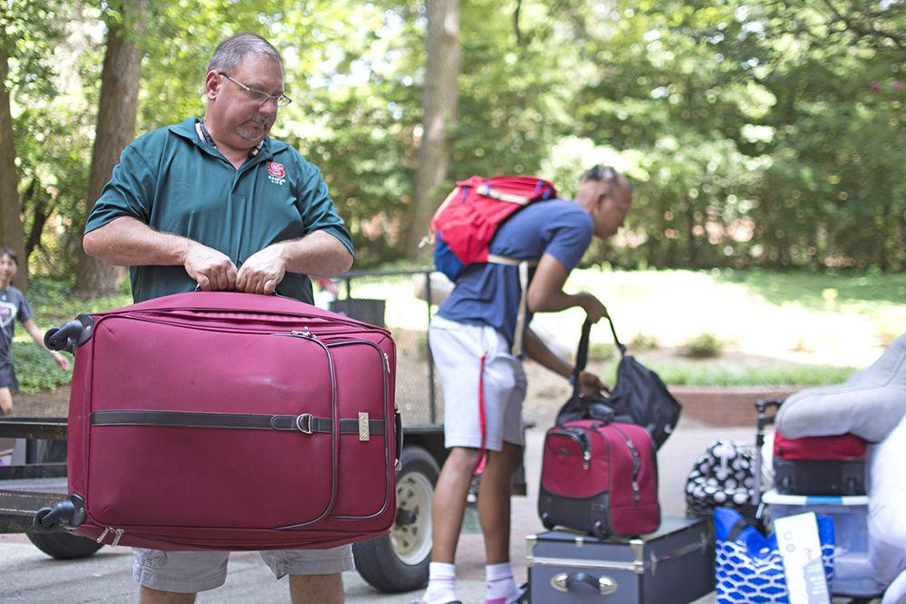 Marc Bledsoe, a university employee in Housing Facilities Administration, unloads a tram of luggage during Wolfpack Welcome Week, Friday, Aug. 17, outside of Metcalf Residence Hall. The tram has been in use for eight years, and allows student to load luggage from Coliseum Deck and have it transferred to outside of their respective living space.
