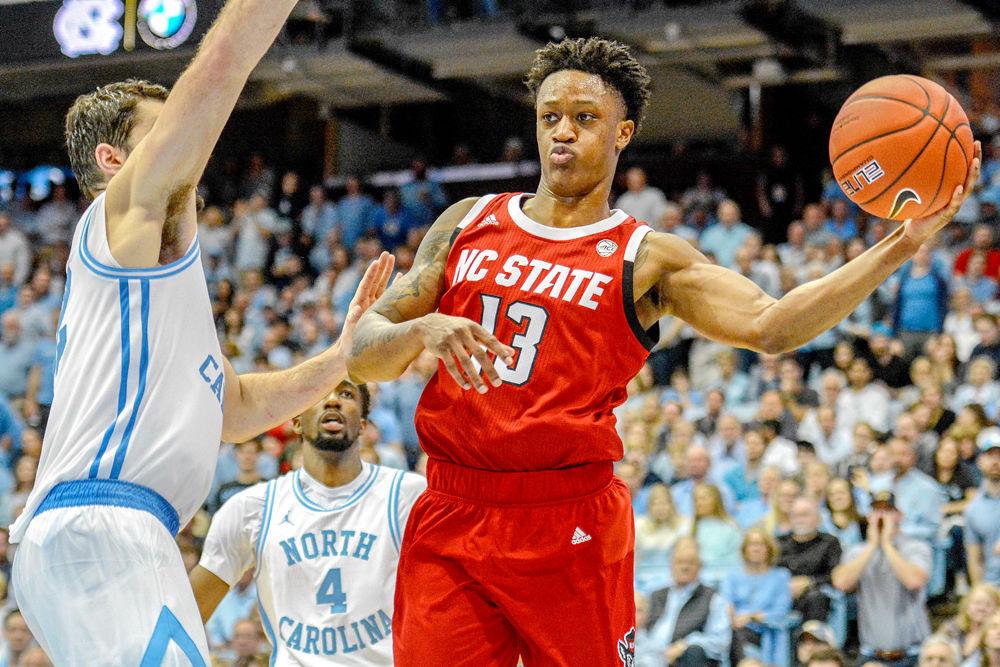 Redshirt junior guard C.J. Bryce kicks out the ball from the interior while being guarded by UNC-Chapel Hill forward Luke Maye on Tuesday, Feb. 5 in the Dean E. Smith Center. Bryce scored 15 points against UNC as the Wolfpack lost 113-96.