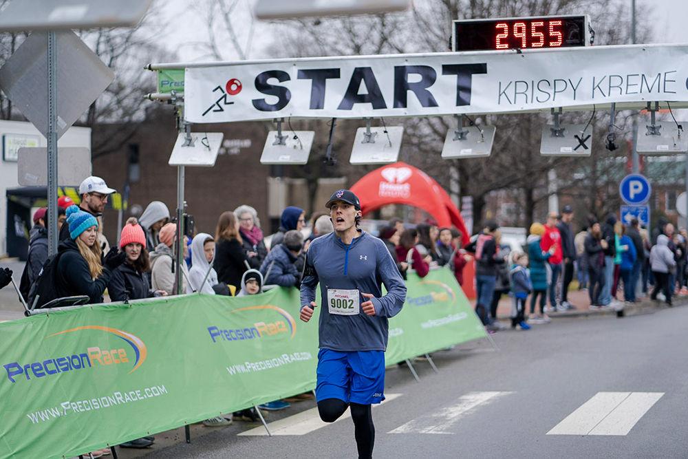 Local runner Michael Aiduk crossing the finish line during the 16th Krispy Kreme Challenge on Saturday, Feb. 1.