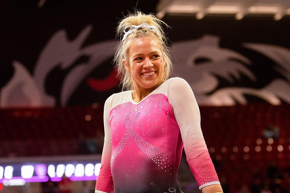 Junior Kasey Nelson smiles during her floor performance on Saturday, Feb. 15 at Reynolds Coliseum. Nelson tied at ninth place in the Floor excercise with an individual score of 9.825.