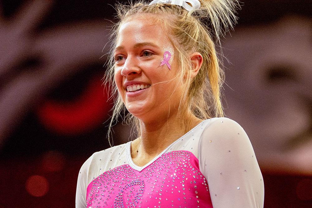 Junior Kasey Nelson smiles after her floor performance on Saturday, Feb. 15 at Reynolds Coliseum. Nelson tied at ninth place in the Floor excercise with an individual score of 9.825.