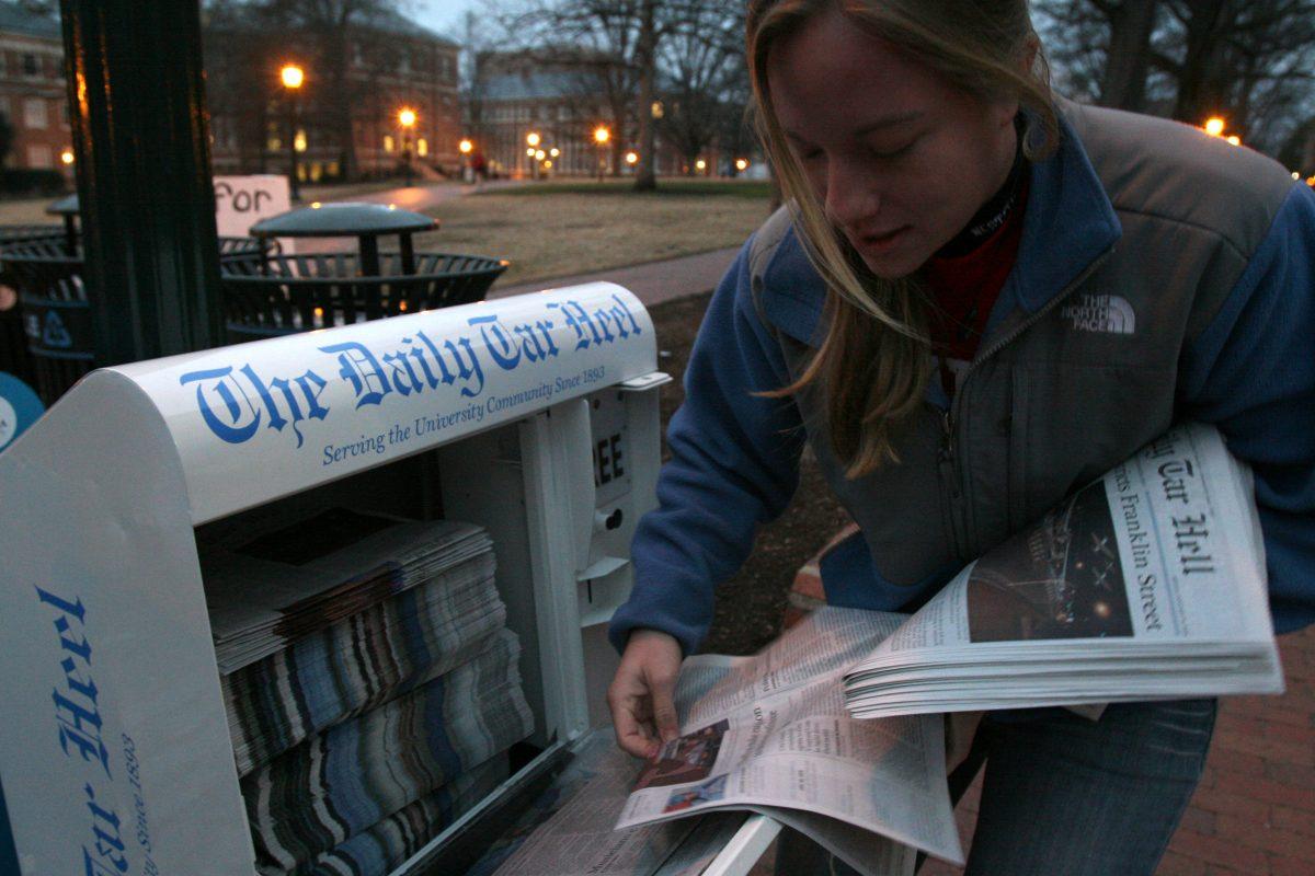 Technician photographer Peggy Boone delivers copies of the satirical Daily Tar Hell edition to UNC's campus early morning on Jan 30, 2009. The production of the Daily Tar Hell has been a tradition that often precedes the spring Wolfpack and Tar Heel basketball rivalry game. Photo by Matt Moore