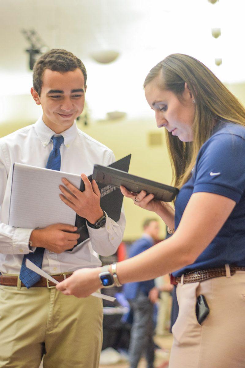 Kristen Harman, a power engineer at Power and Recovery at WestRock takes a photo of a resume from Edgardo Gonzalez, a sophomore in industrial engineering at the Engineering Career Fair on Wednesday, Feb. 5, 2020 at the McKimmon Center. The Career Fair helps students and attendees network with companies looking for employees and interns.