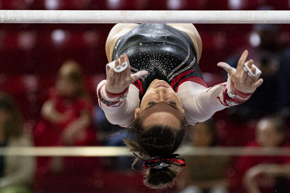 Junior Lauren Kent performs on the uneven bars on Friday, Feb. 21 at Reynolds Coliseum. The Wolfpack took first place in the tri-meet against William &amp; Mary and Centenary with a score of 196.500.