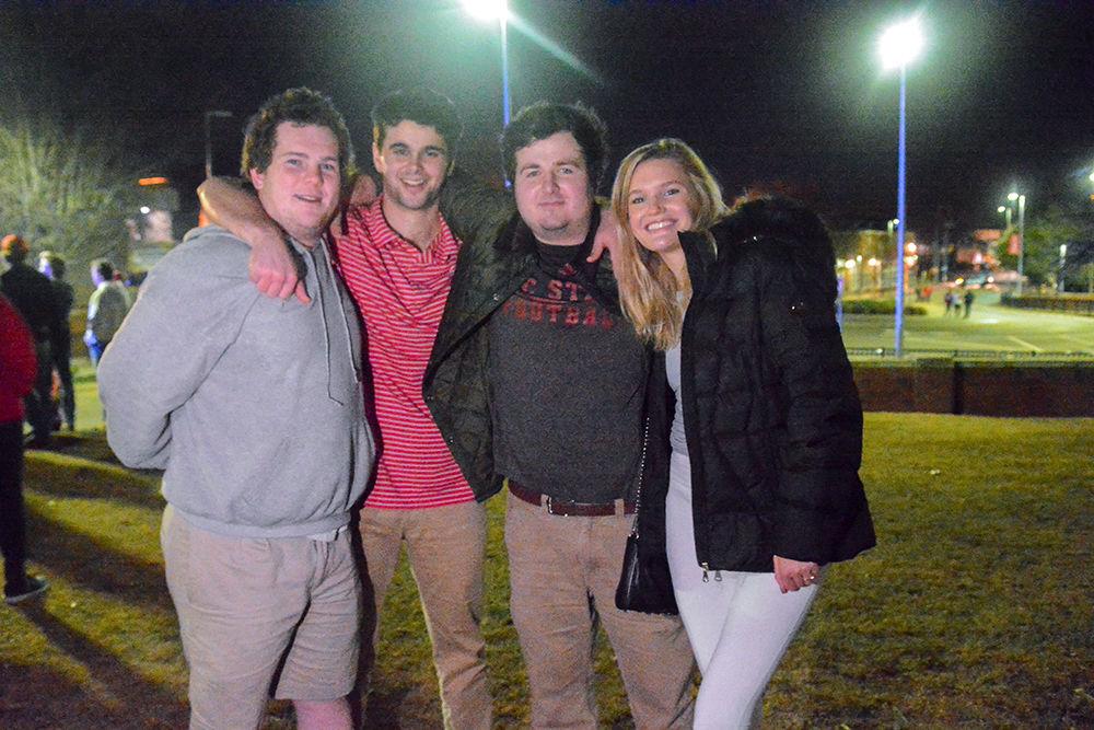 Myers Dean, a senior in political science, Brad Mickle, a junior in business administration, Anton O&#8217;Brien, a junior in business administration and Eliza Irwin, a junior in fashion &amp; textile management smile as they rush the Bell Tower after the 88-66 win over Duke on Wednesday, Feb. 19, 2020. Hillsborough Street flooded with Wolfpack fans in support of the men&#8217;s basketball team win.