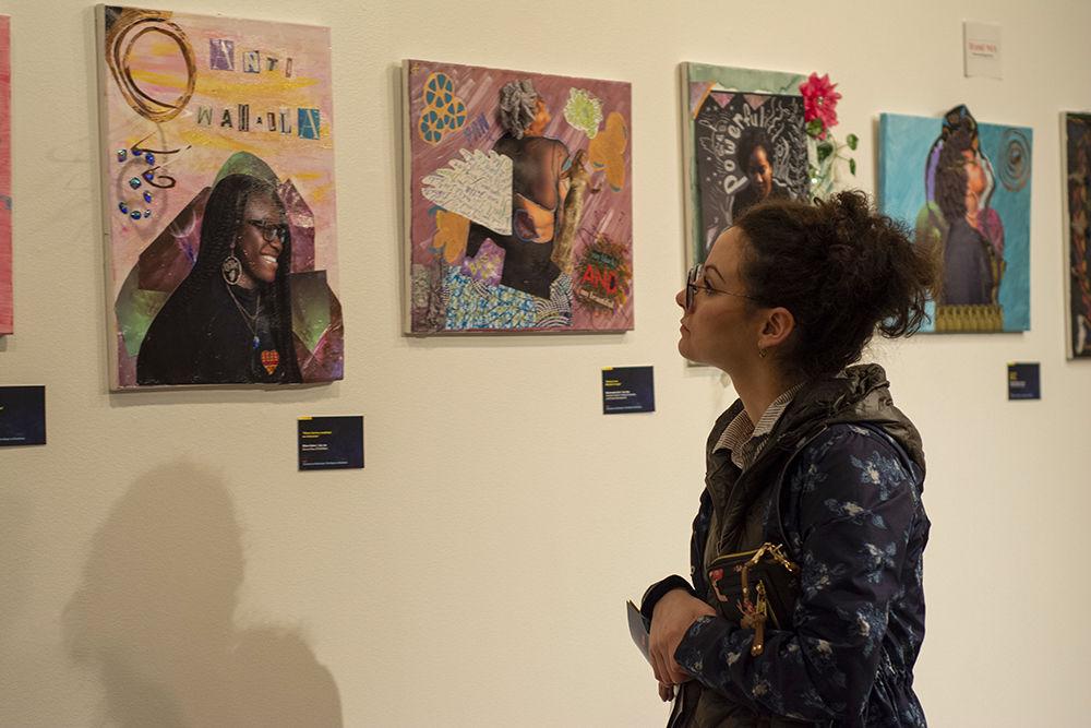 Maria Tudela looks at art on display at the Existence as Resistance: The Magic in Blackness exhibit. The exhibit opened on Feb. 18, 2020 in the African American Cultural Center Art Gallery.